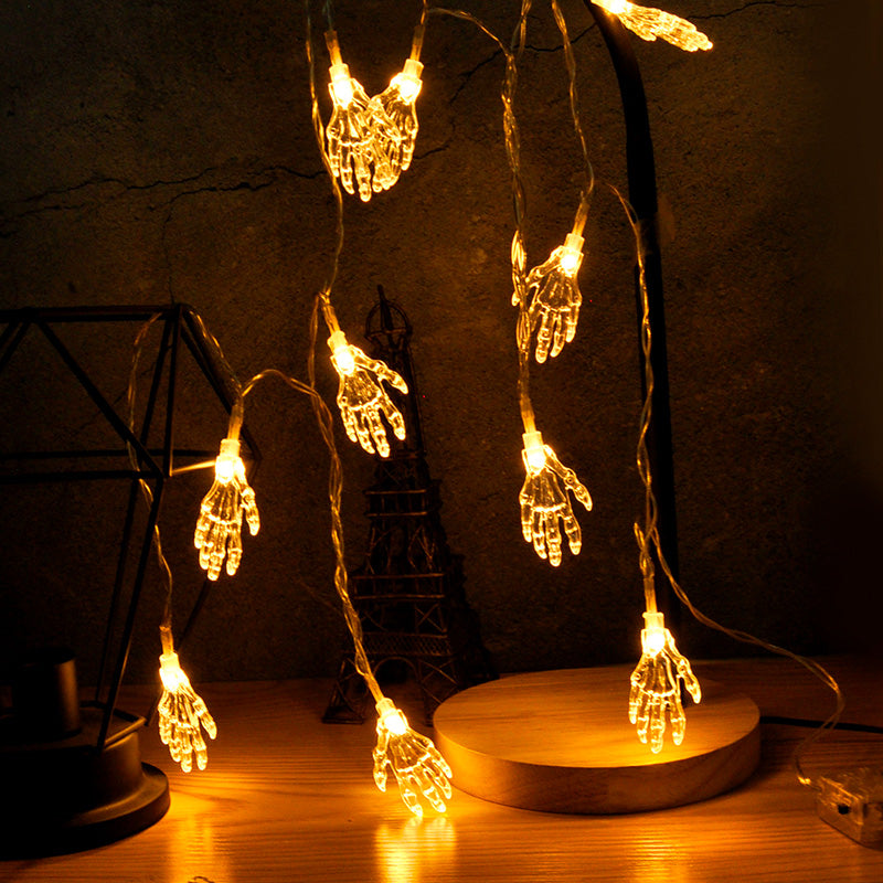 Skeleton hand LED string lights unlit on white background with battery pack