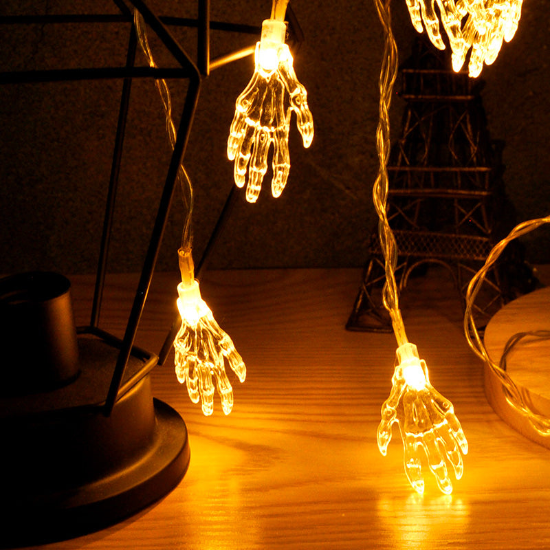 Skeleton hand LED string lights glowing warm white hanging in dark display