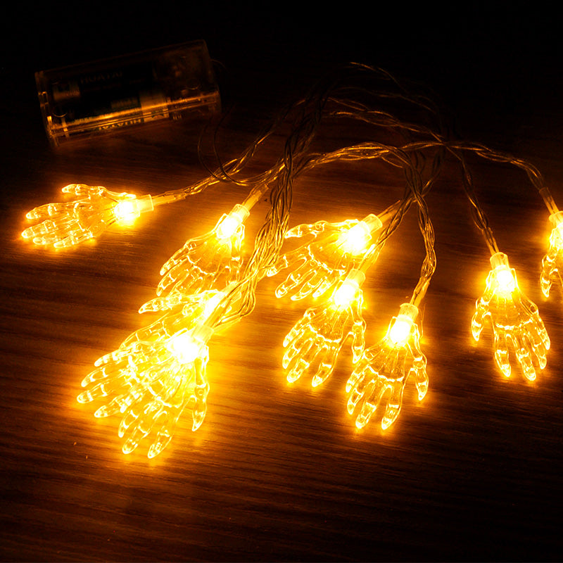 Skeleton hand string lights glowing on black fabric Halloween display