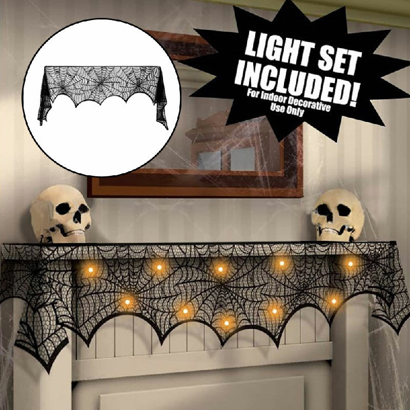 Black lace spiderweb Halloween scarf with warm fairy lights glowing through on mantle