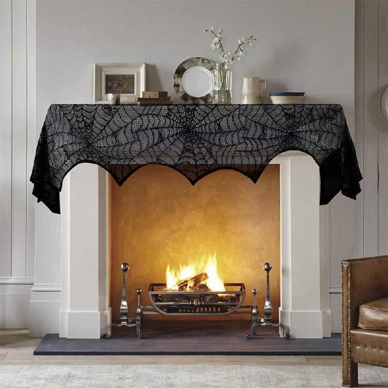 Halloween lace spiderweb scarf draped over fireplace with skulls and Halloween accessories